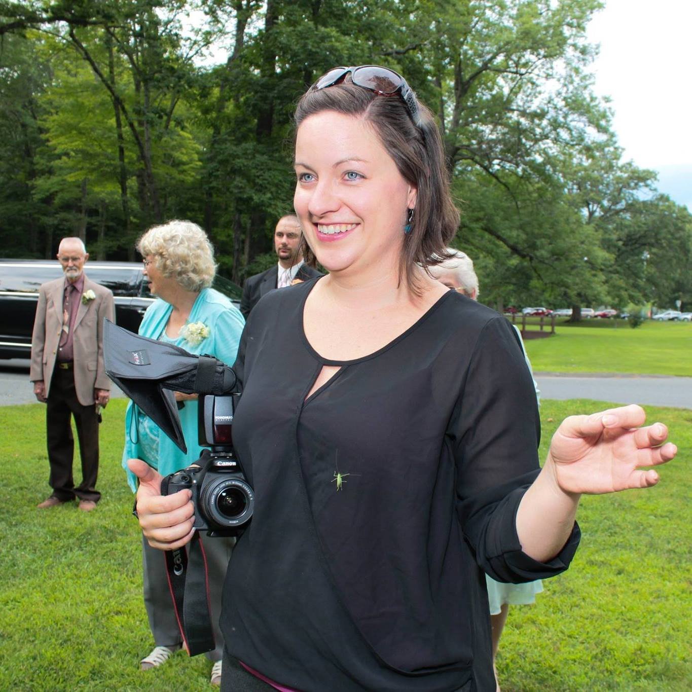 Heather Blake with a camera in her hand as she photosgraphs a wedding, her first business she created.
