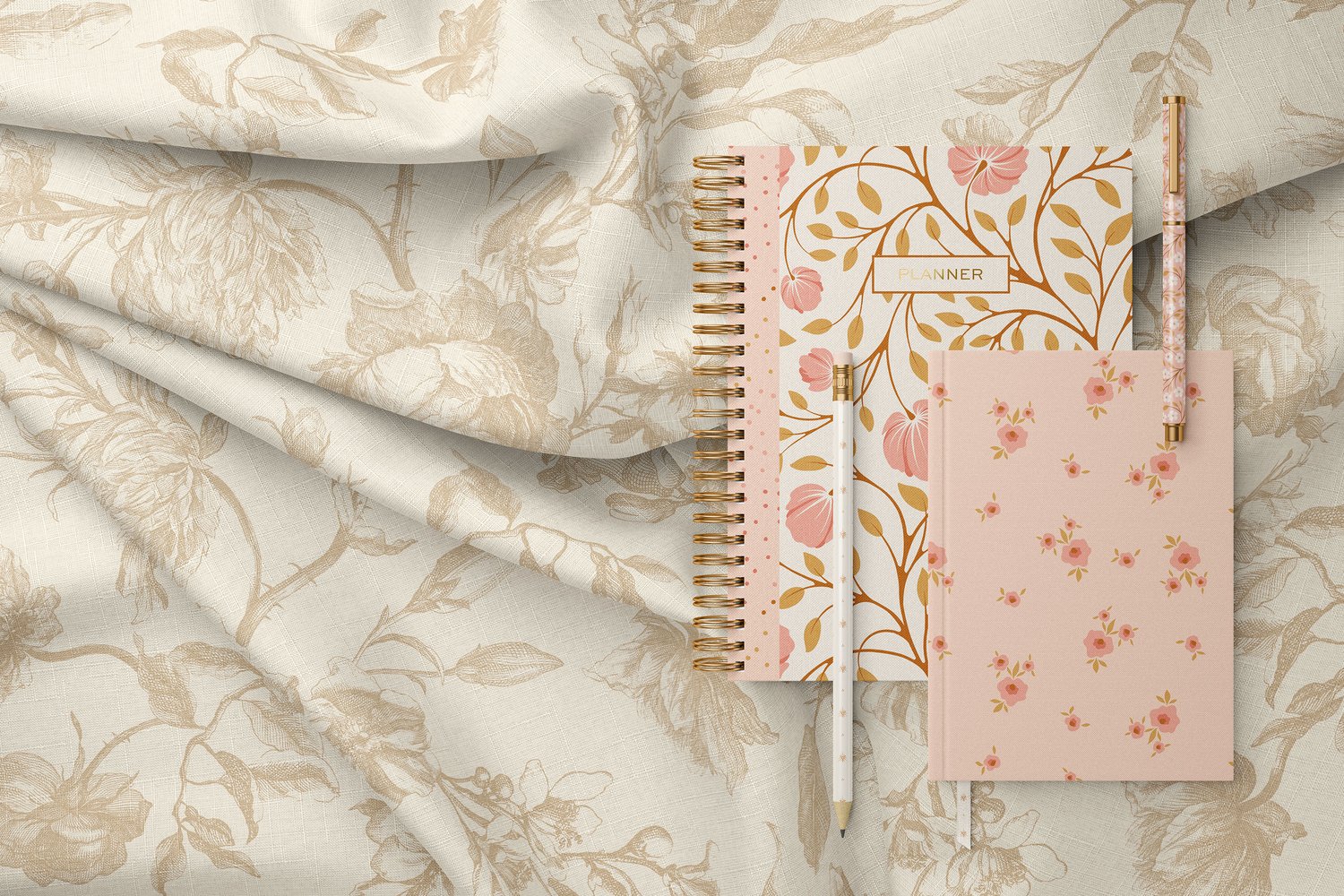 pink floral notebooks and pencils on a neutral floral fabric background