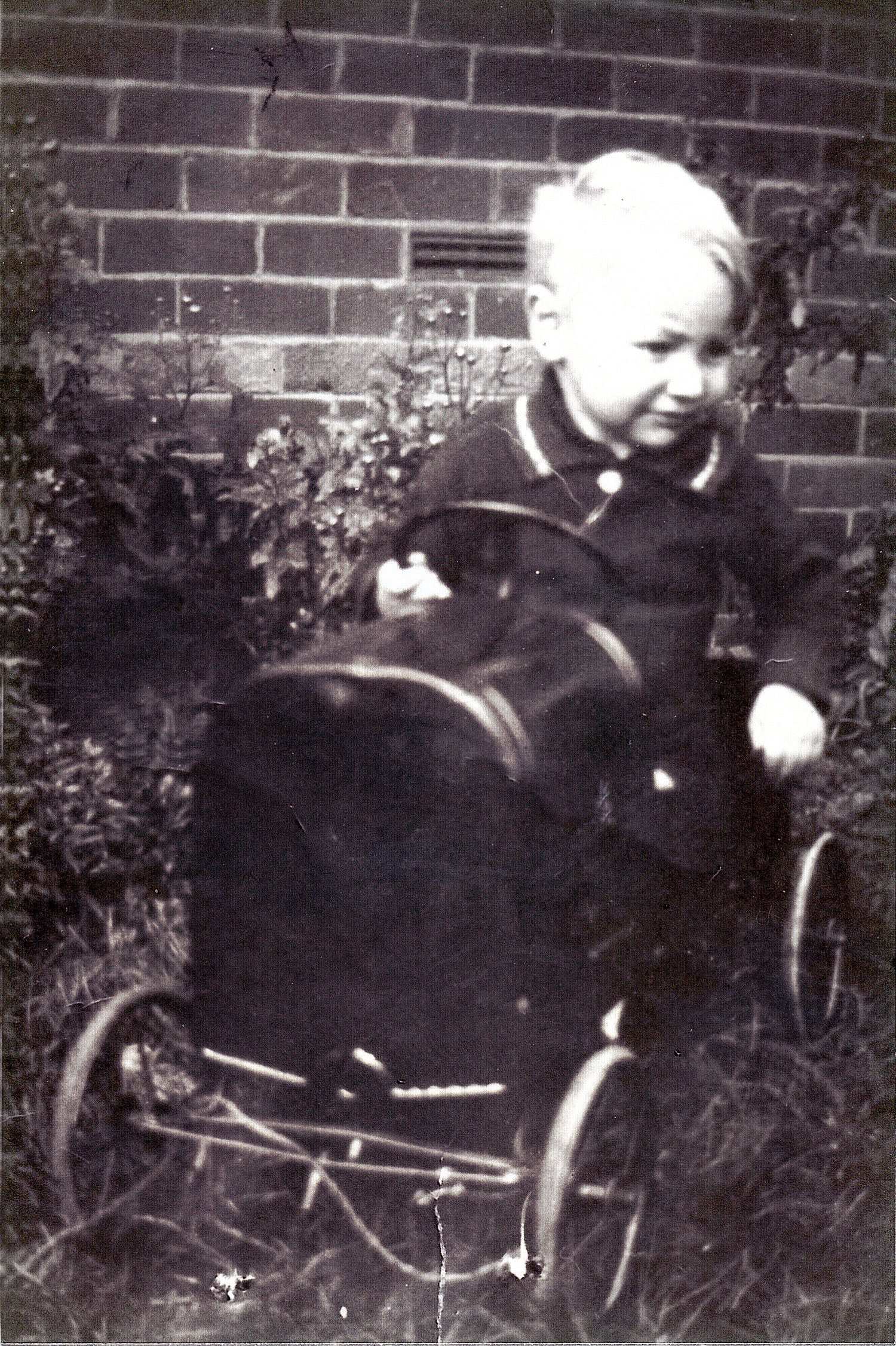 Harry Drabble, aged about 18 months old, in a bright red metal car