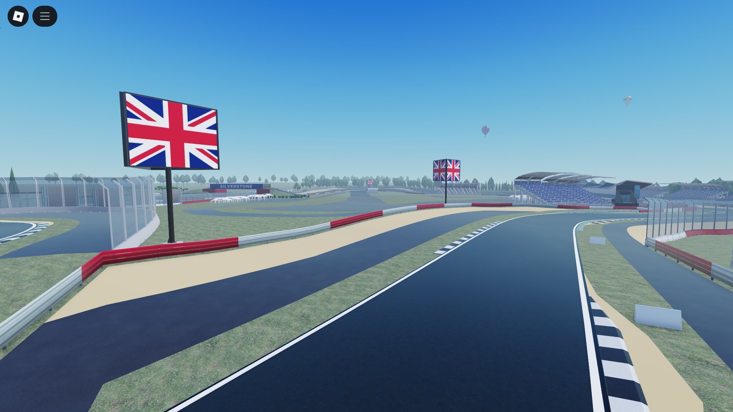 Trackside grass and barriers along a racing curve