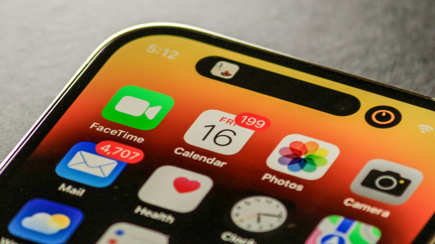 Close-up of a smartphone screen showing hundreds of unread emails and notifications glowing red against a warm gradient background, echoing the theme of attention overload explored in The Creative Guide’s “Notifications Are Theft.”