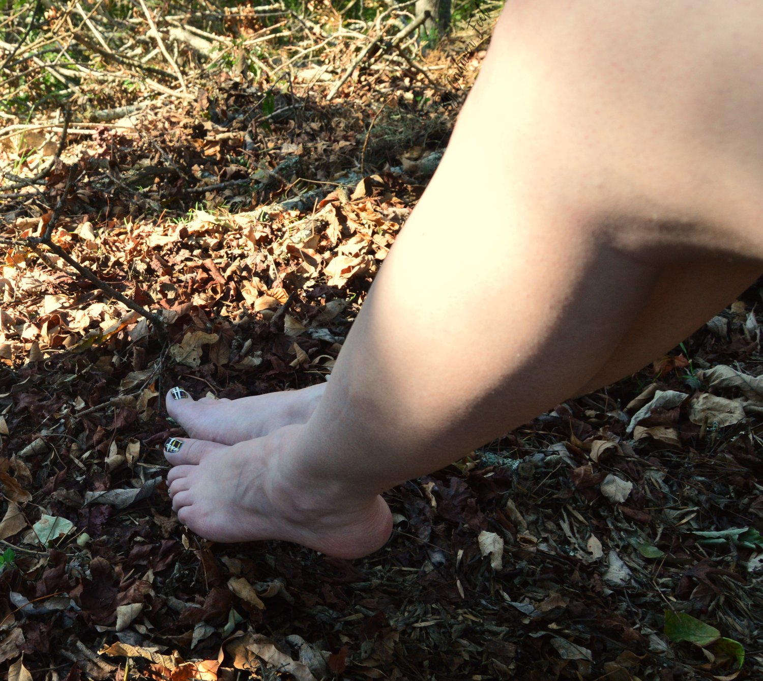 pale feet resting on dried leaves