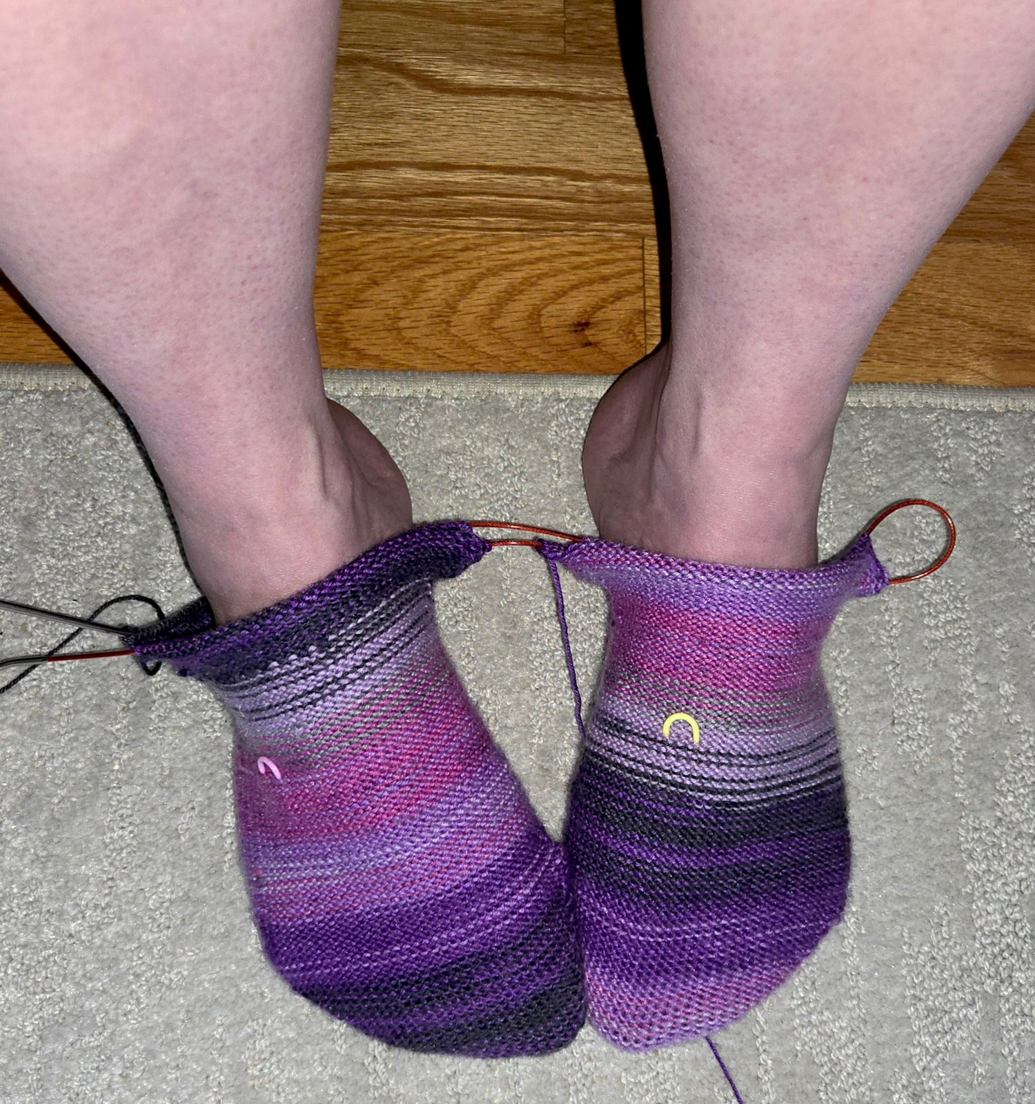 partially knitted socks being tried on toe up to the arches