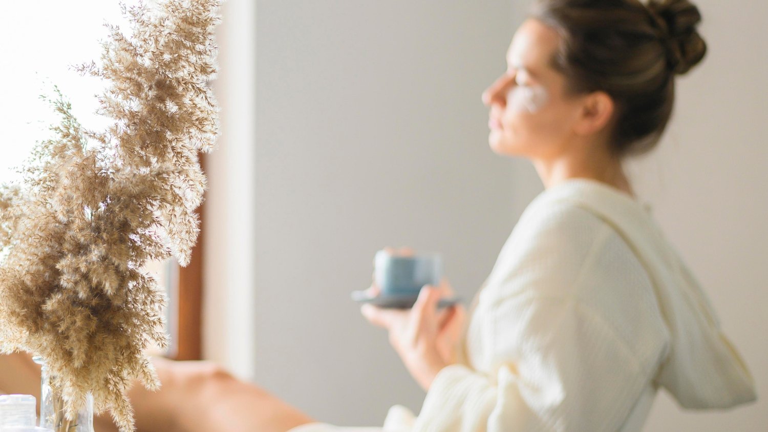 Lady sitting comfortably in a chair with skincare products, calm self-care routine