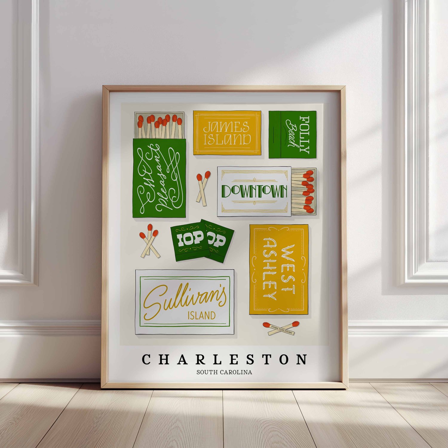 A framed picture of Charleston, South Carolina neighborhoods drawn in various lettering styles on matchboxes. Artwork has a green, yellow and white color scheme.