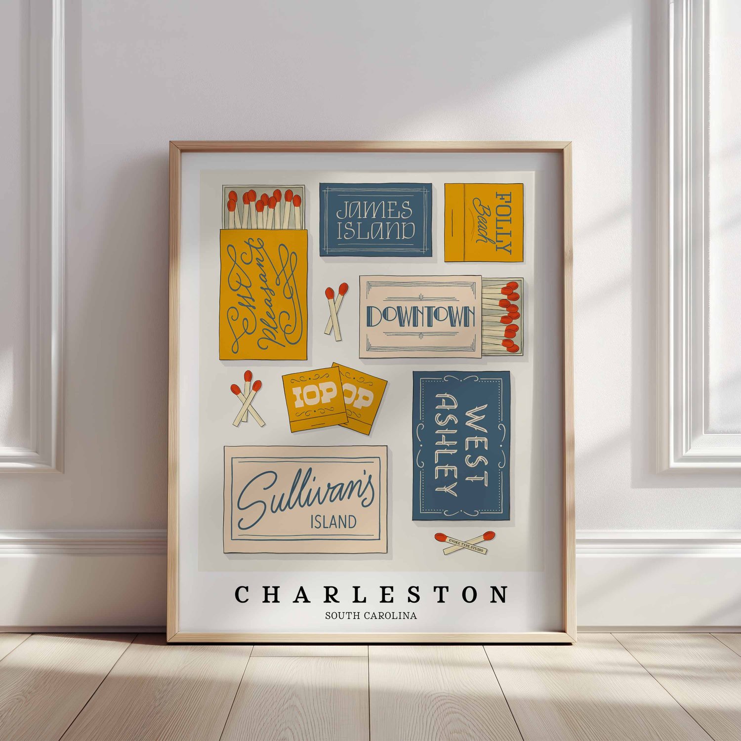 A framed picture of Charleston, South Carolina neighborhoods drawn in various lettering styles on matchboxes. Artwork has a blue, yellow and beige color scheme.