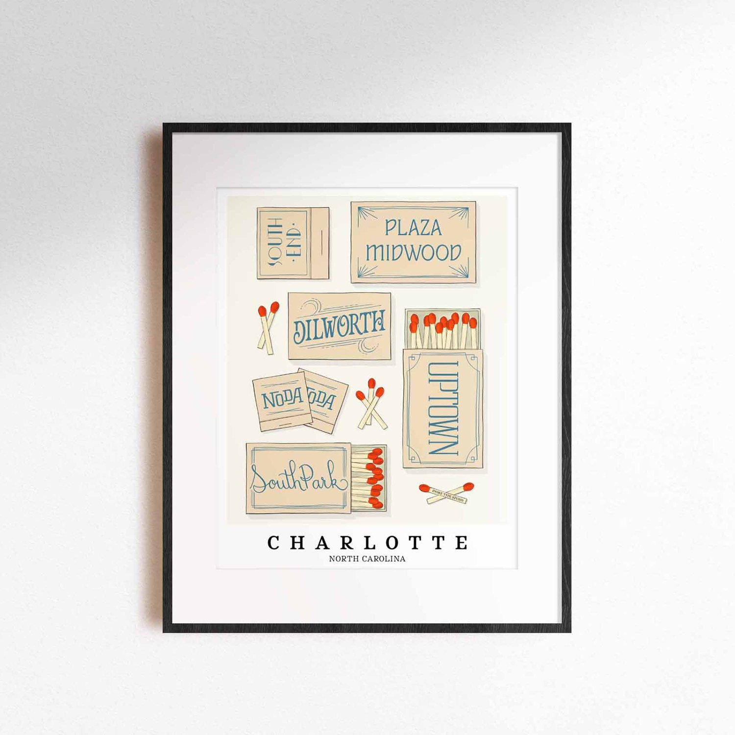 A framed picture of Charlotte, North Carolina neighborhoods drawn in various lettering styles on matchboxes. Artwork has a beige and blue color scheme.