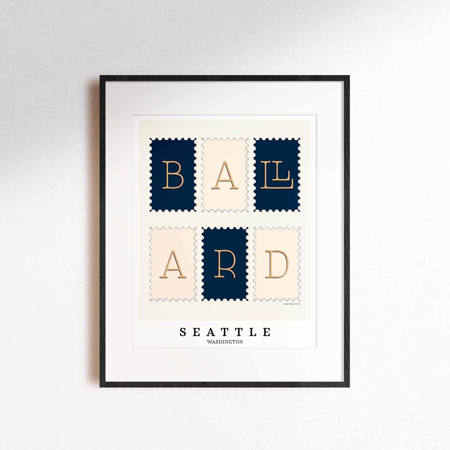 A framed picture of postage stamps featuring the Ballard neighborhood in Seattle, Washington drawn in a unique lettering style. Artwork has a navy blue, beige and tan color scheme