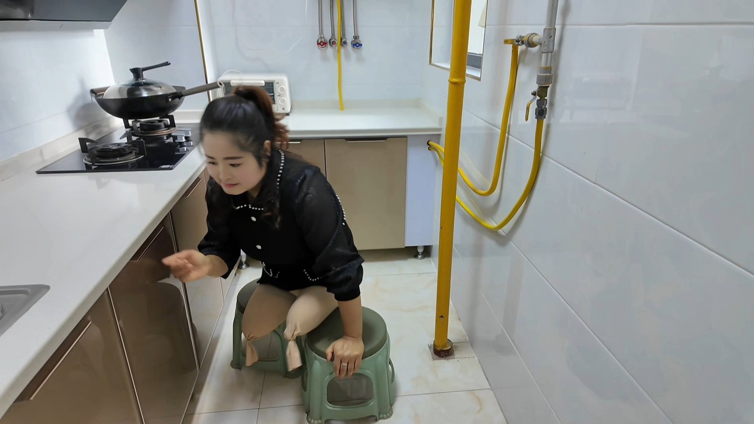 Tina, an amputee girl, uses a stool to go up and down the stairs.