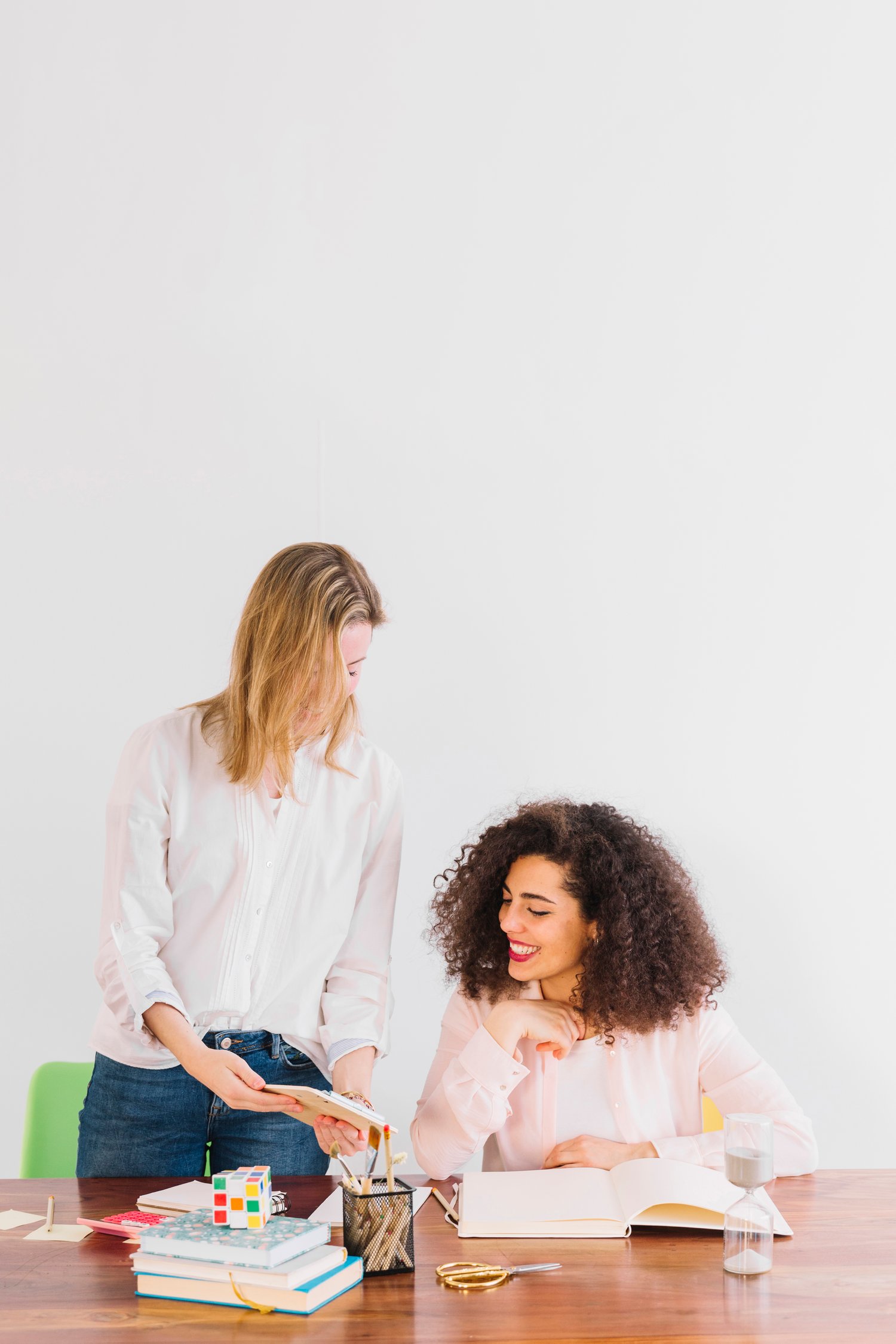 Cheerful women studying together at table