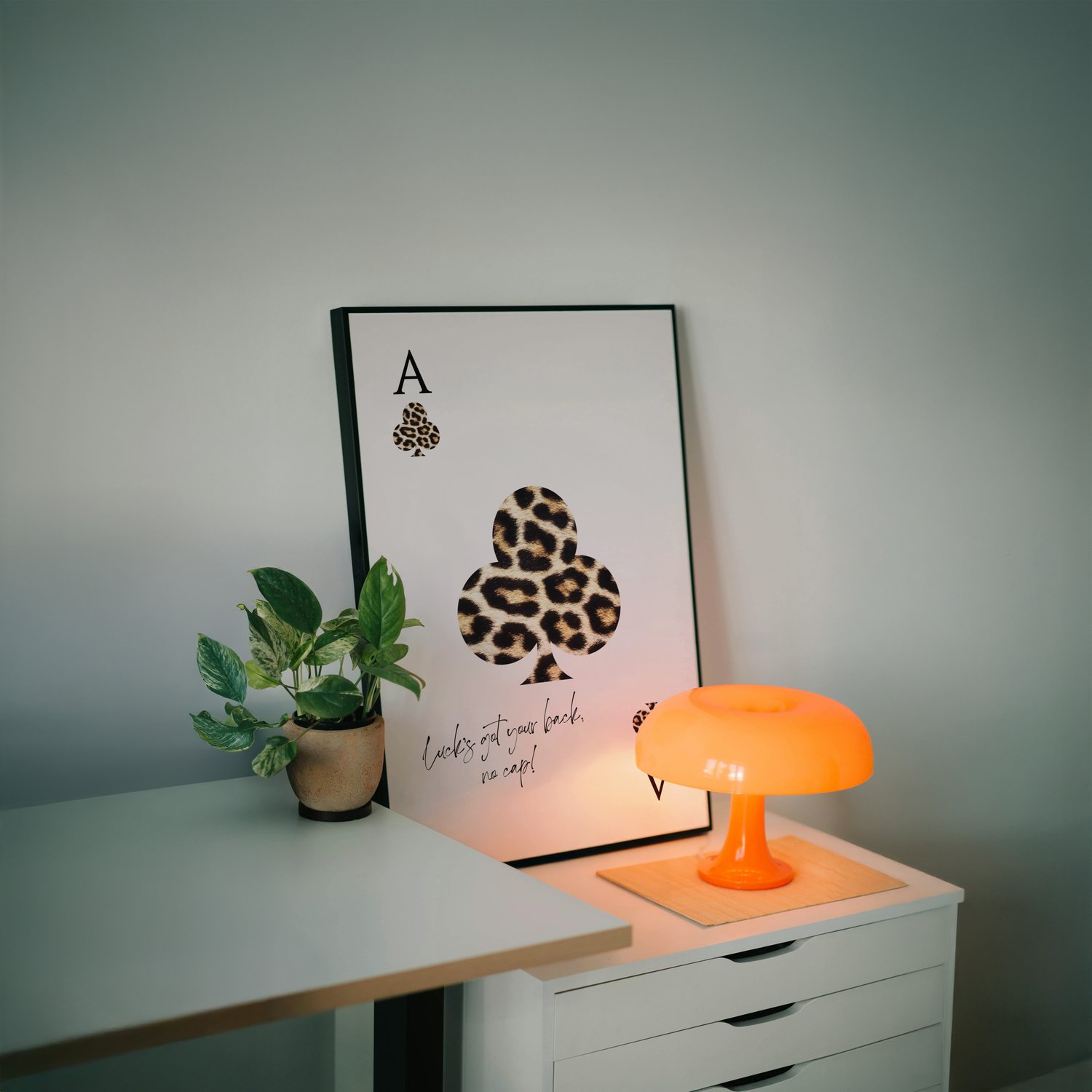 Leopard print playing card wall art poster with quote typography, framed minimalist artwork styled in a modern interior.