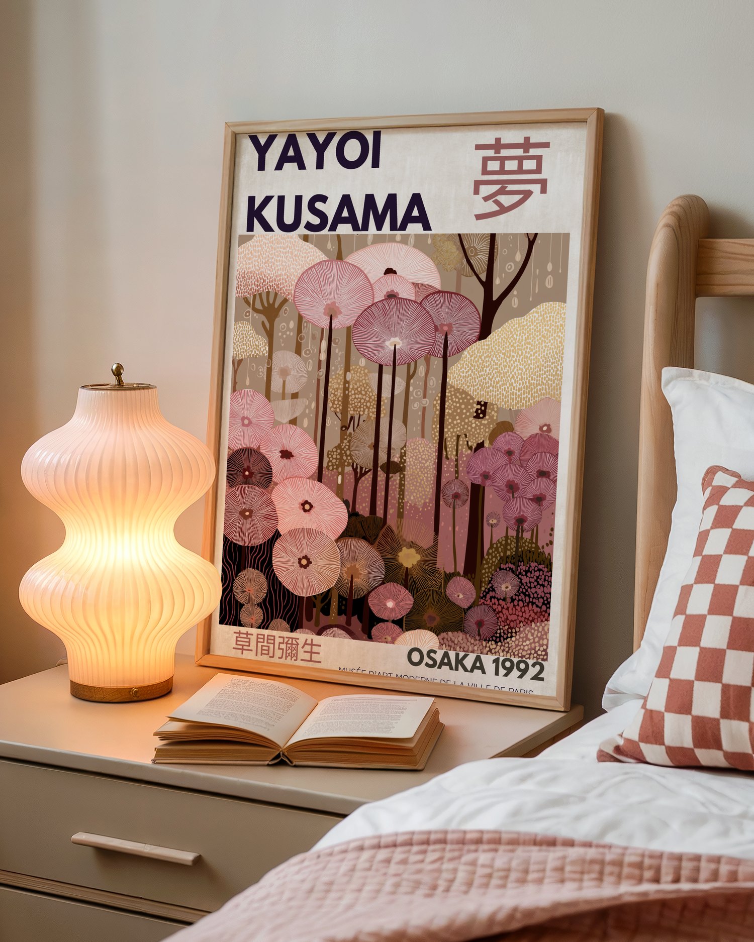 Kusama-inspired abstract wall art poster with floral patterns and Japanese typography, framed in a modern pink-toned interior.