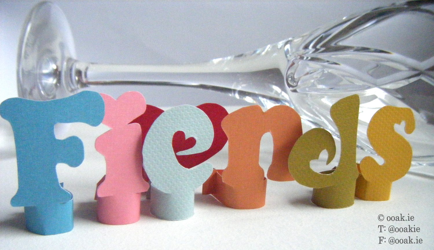 8 printable heart-themed wine glass tags spelling FRIENDS, displayed as DIY drink markers on wine glass stems.