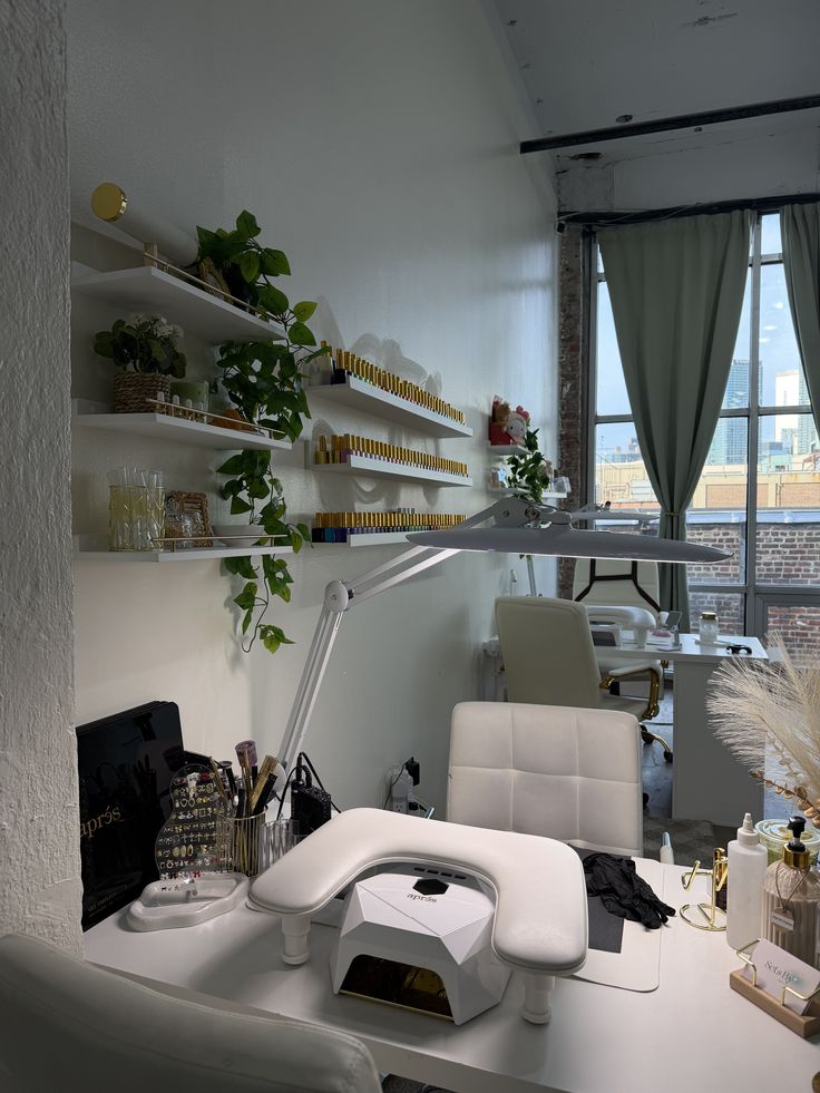 Professional nail technician applying detailed nail art on a client’s hands in a modern nail studio, showcasing skill and precision.