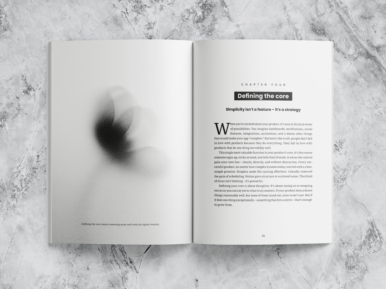 Open book on a marble surface with the text “Defining the core” and “Simplicity isnt a feature – its a strategy.” The left page shows a blurred black-and-white abstract image.