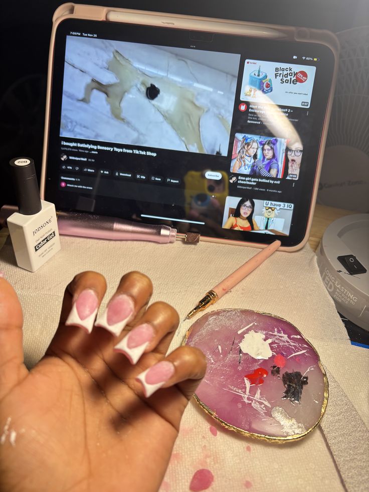 Nail technician painting intricate nail art on a client’s nails in a clean, well-lit nail studio, showcasing professional skill and precision.