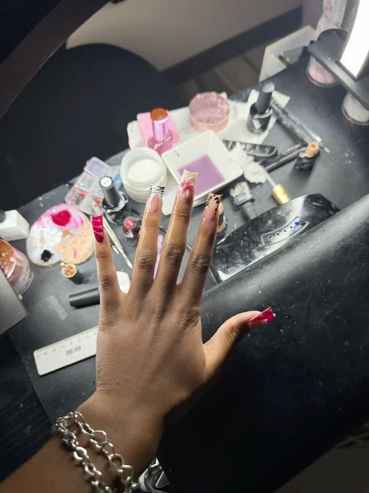 Nail technician practicing detailed nail art on a client’s hands in a clean, organized studio, demonstrating focus, precision, and consistency.