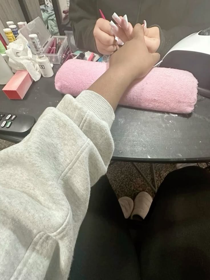 Nail technician painting detailed nail art in a modern, organized studio, demonstrating precision, focus, and consistent skill development