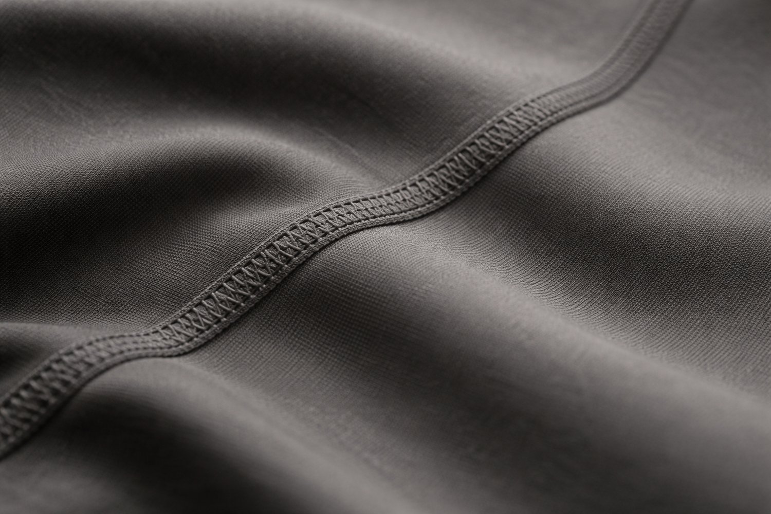 Close-up of matte athletic fabric with a stitched seam, highlighting the texture and construction of women’s sports uniforms.