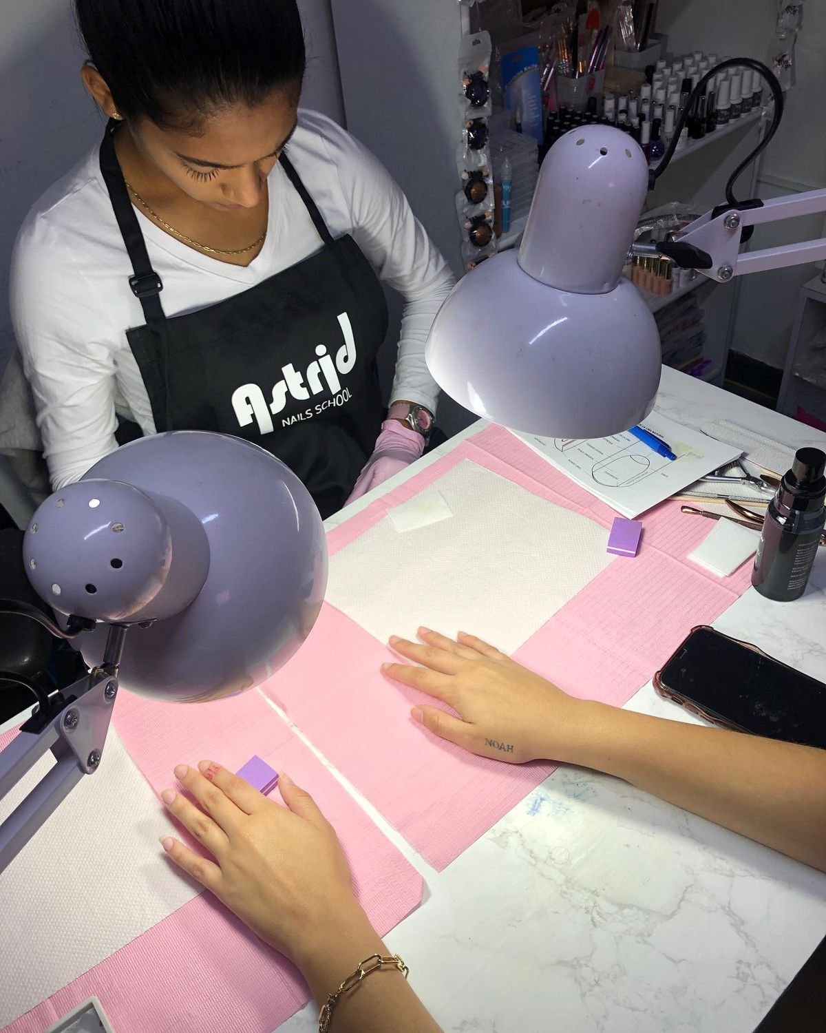 Nail technician professionally discussing nail services with a client in a clean, modern studio, demonstrating calm and effective client management.