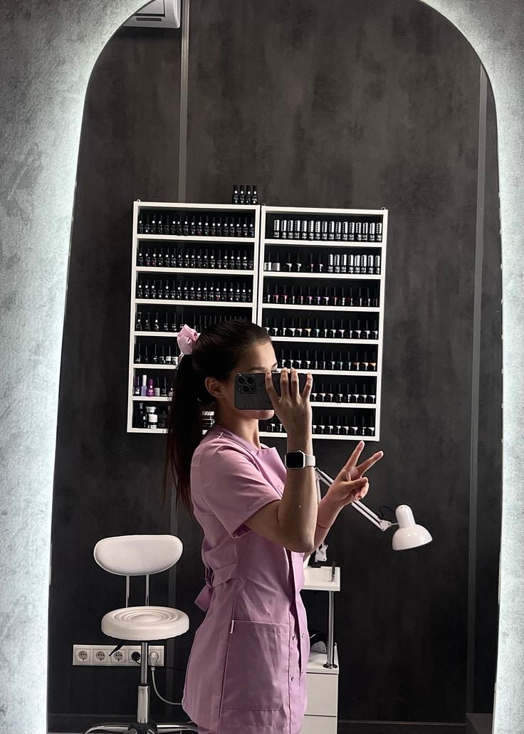 Nail technician applying intricate floral nail art to a client’s nails in a clean, modern studio, showcasing creative and professional nail designs.