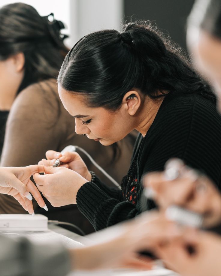 Nail technician calculating service pricing in a modern studio, demonstrating how to set profitable nail service prices.