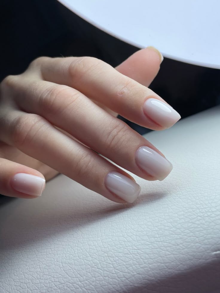 Nail technician interacting with a smiling client in a modern studio, demonstrating strategies for client retention in a nail business.