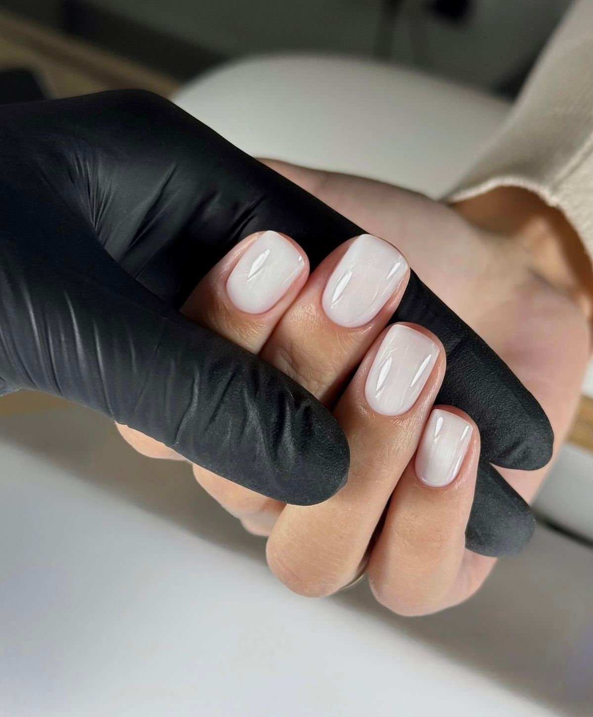 Nail technician taking a professional photo of her nails and studio, demonstrating personal branding strategies for nail techs
