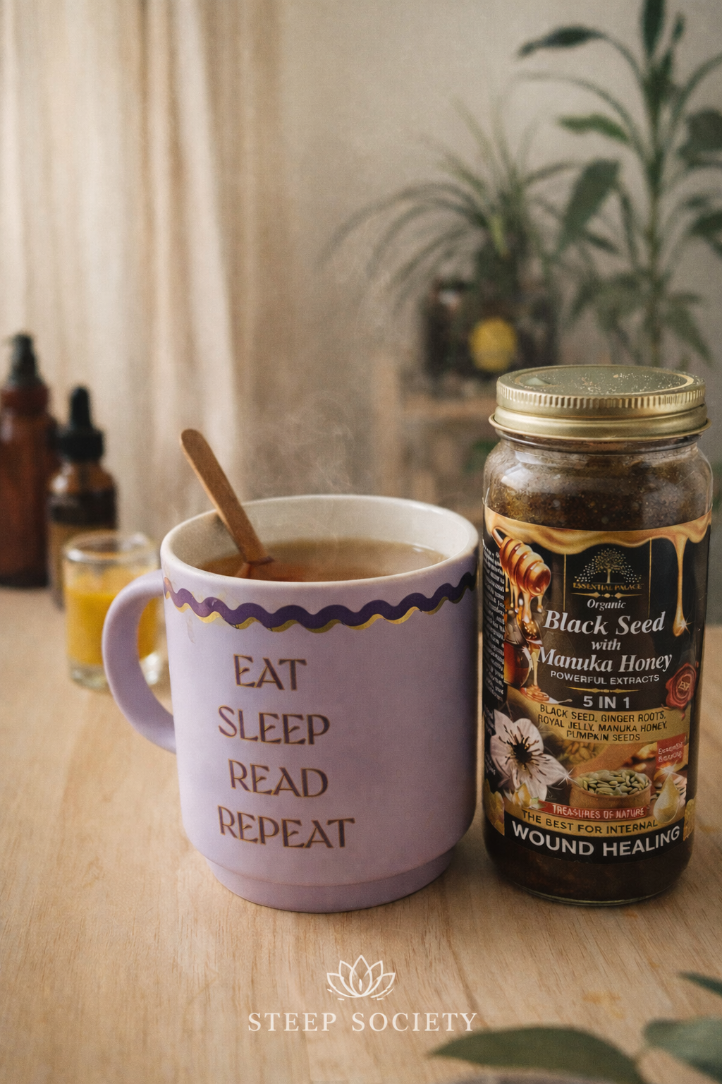 Puple Eat, Sleep, Read, Repeat Mug with tea filled in it, next to a jar of Black Seed with Manuka Honey.