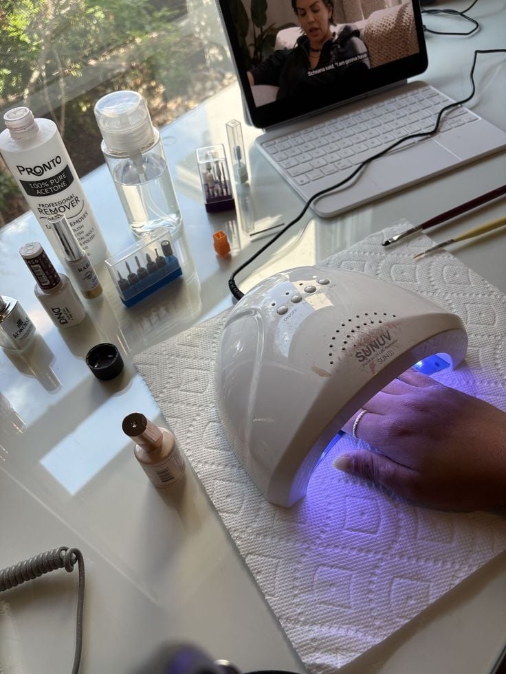 Nail technician presenting polish swatches and add-on services to a client, demonstrating ways to increase revenue per appointment