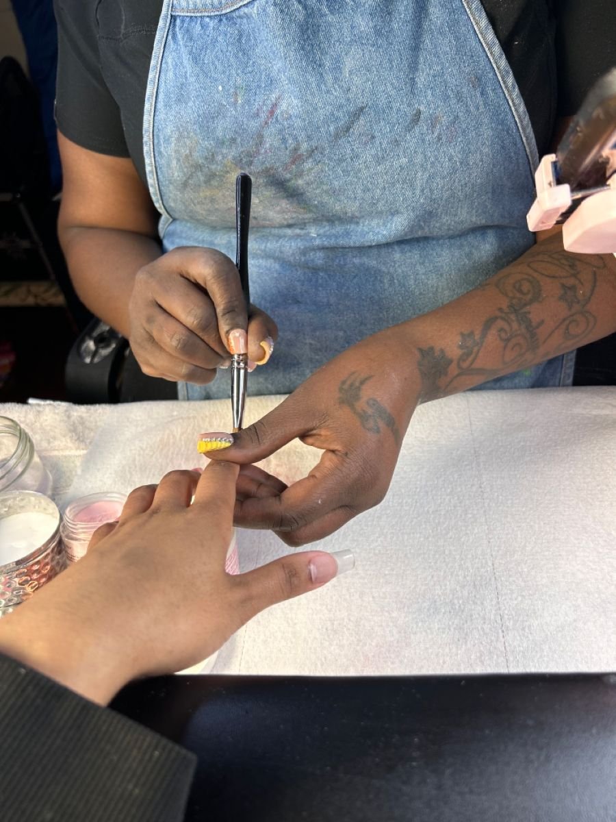 Nail technician presenting a pricing menu to a client, demonstrating professional pricing strategies for nail services.