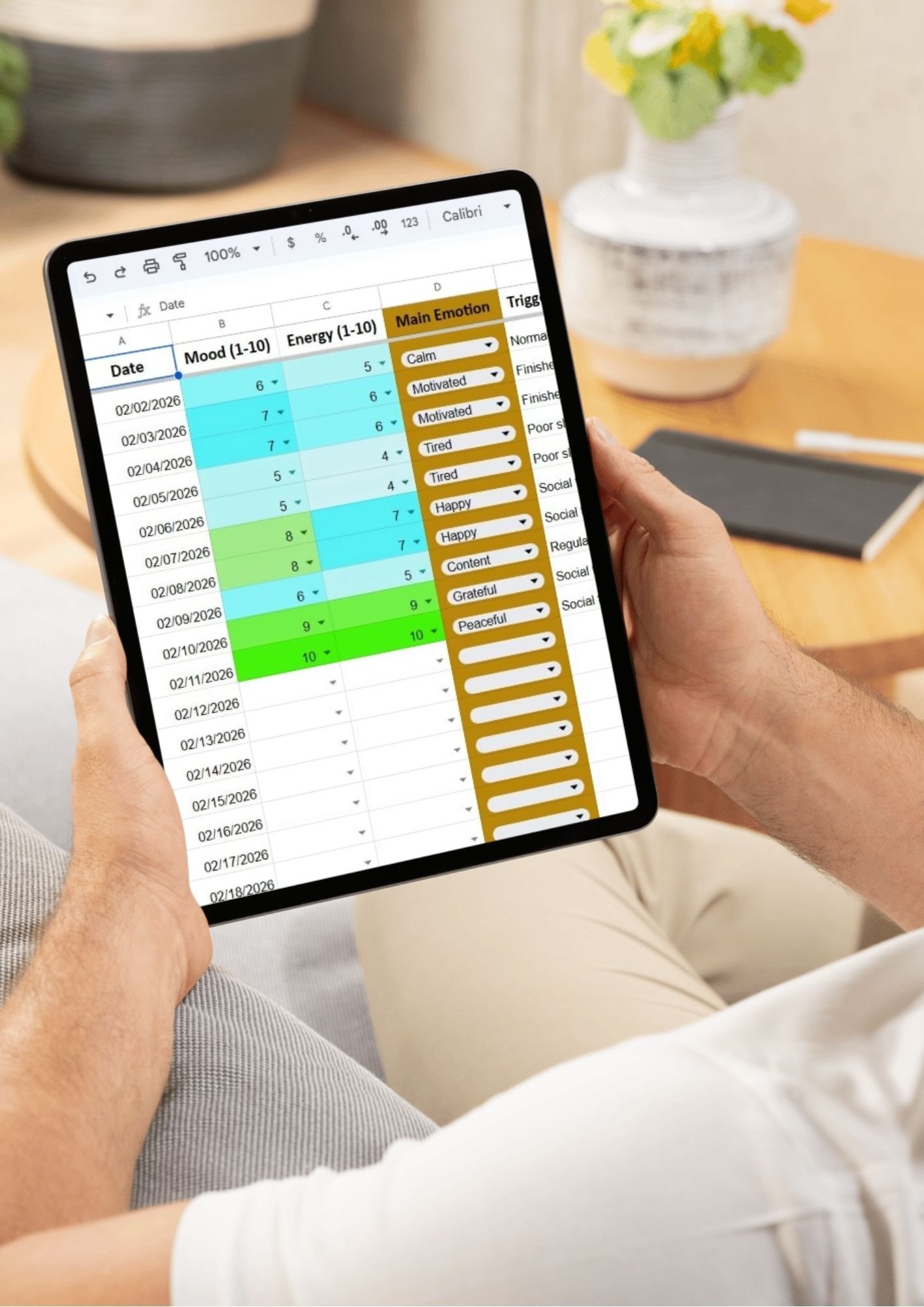 Digital Mental Health Journal being used on a tablet, showing a color-coded Google Sheets habit tracker with dropdown menus for emotions like Calm, Motivated, and Peaceful.