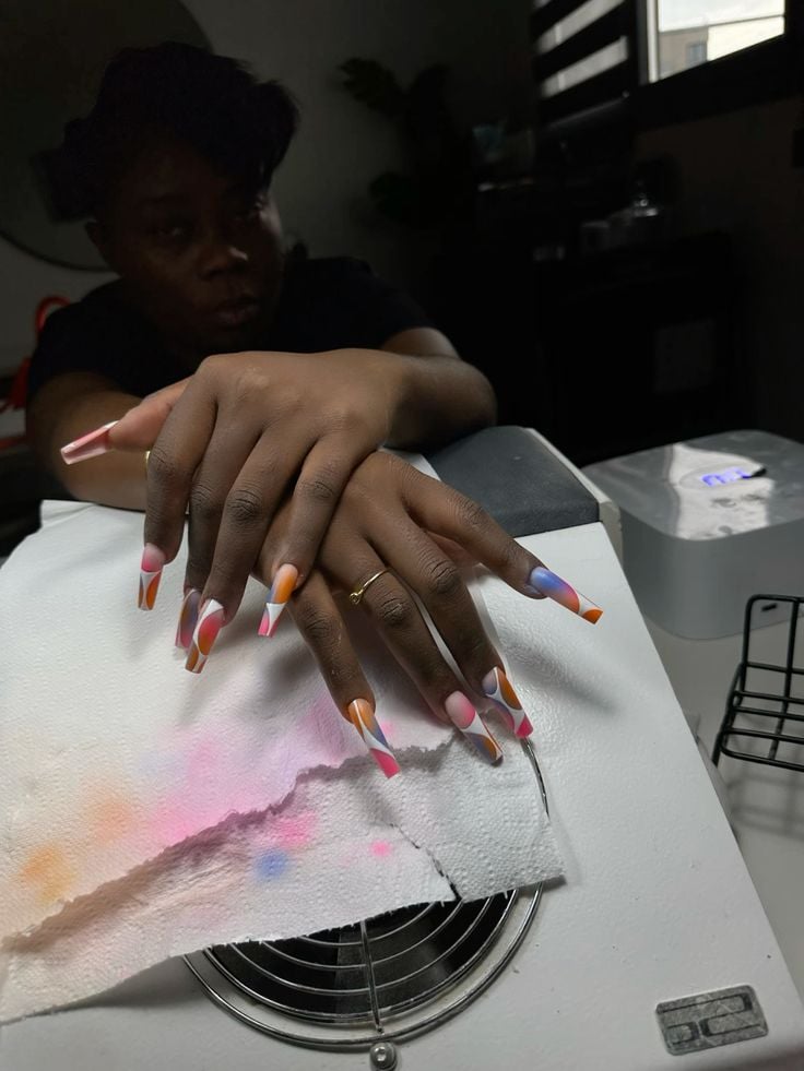 Nail technician giving a referral card to a client to encourage referrals and grow a nail business.