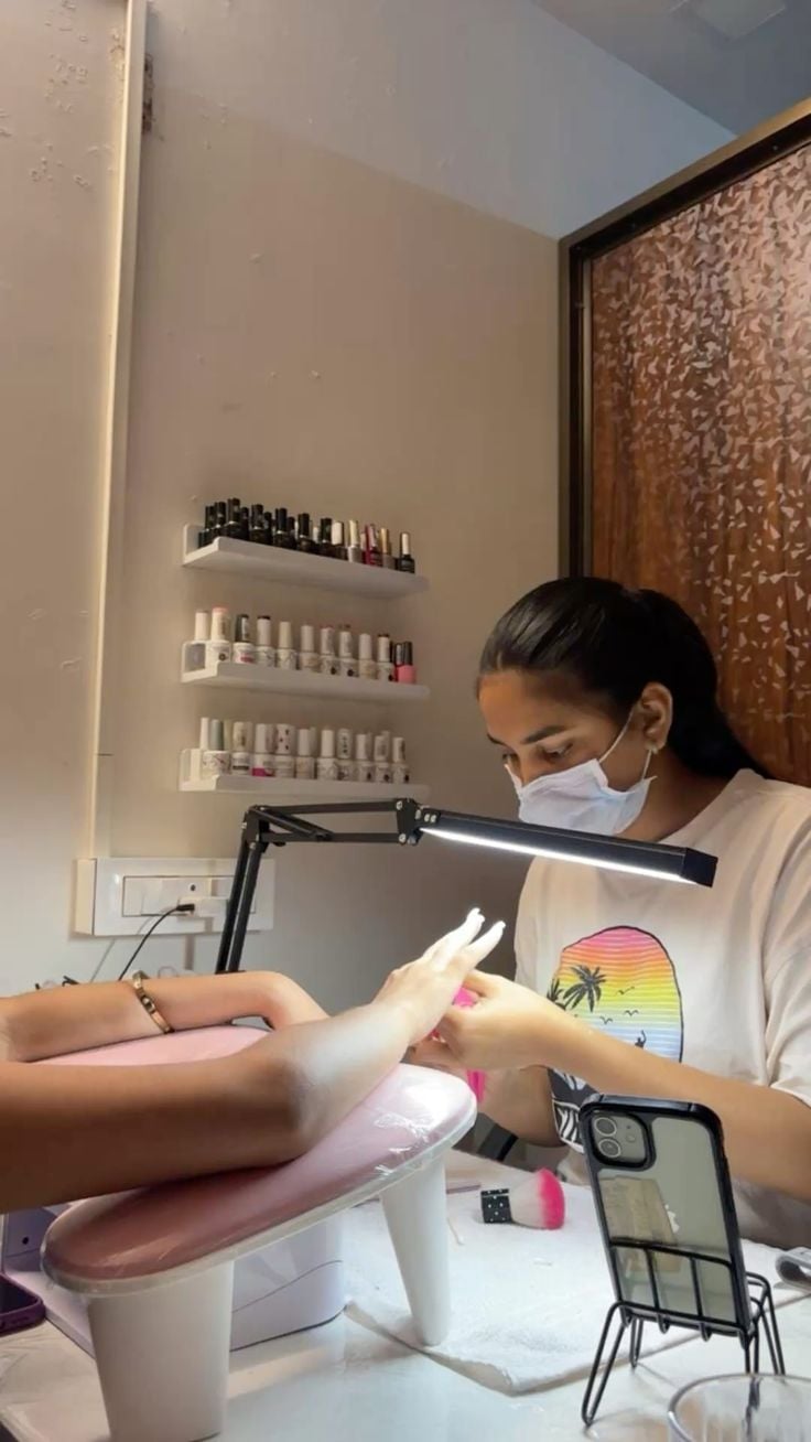 Nail technician creating a stunning nail portfolio to attract clients and grow the business.