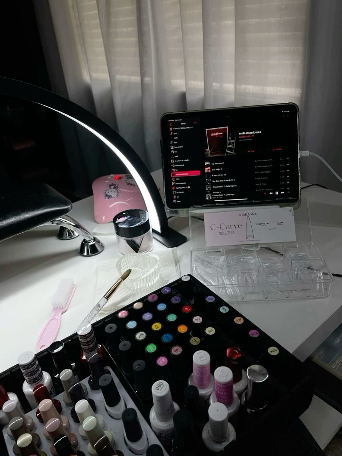 Nail technician creating a relaxing client experience in a calm, professional studio to grow the business.