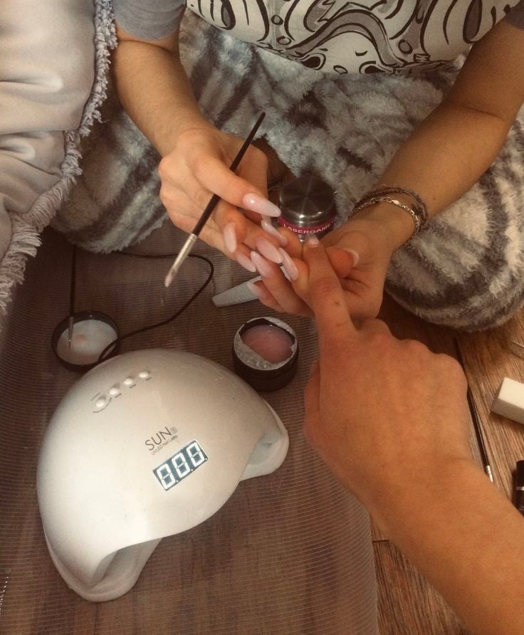 Nail technician providing nail care education to clients to improve satisfaction and grow the business.