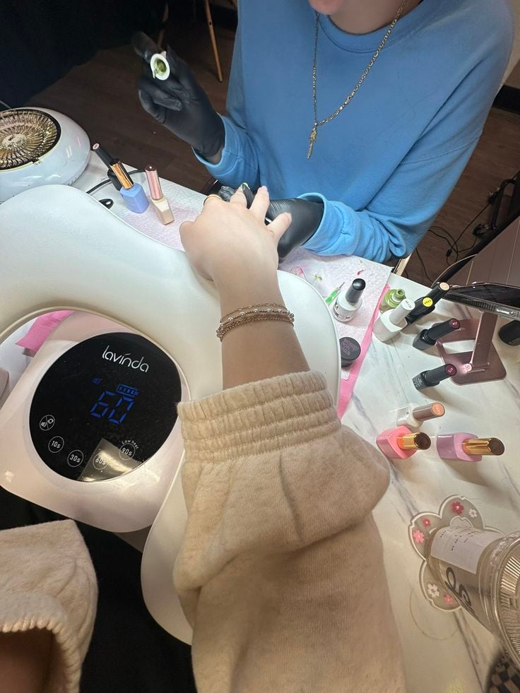 Nail technician presenting a client loyalty program to increase repeat bookings and grow the business