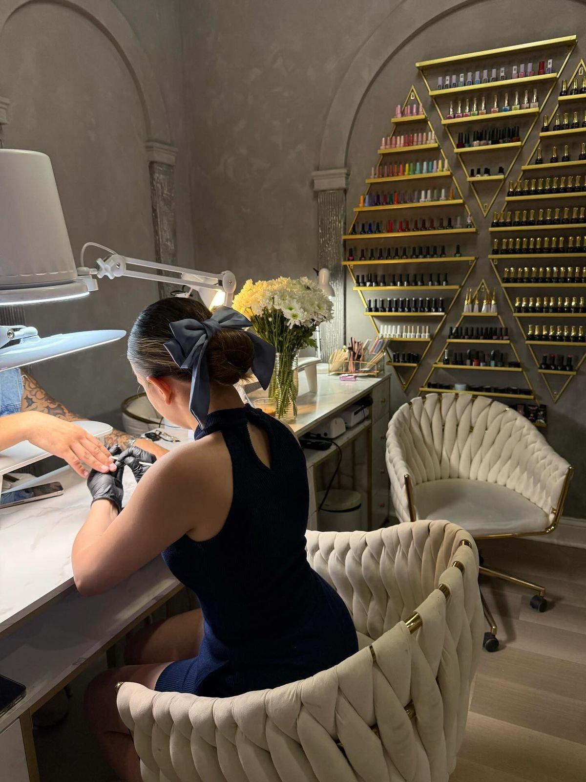 Nail technician managing a busy appointment day efficiently to provide excellent service and grow the business.