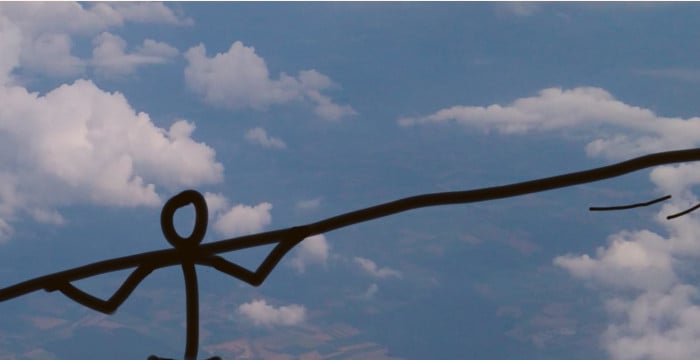 top half of figure walking a tightrope