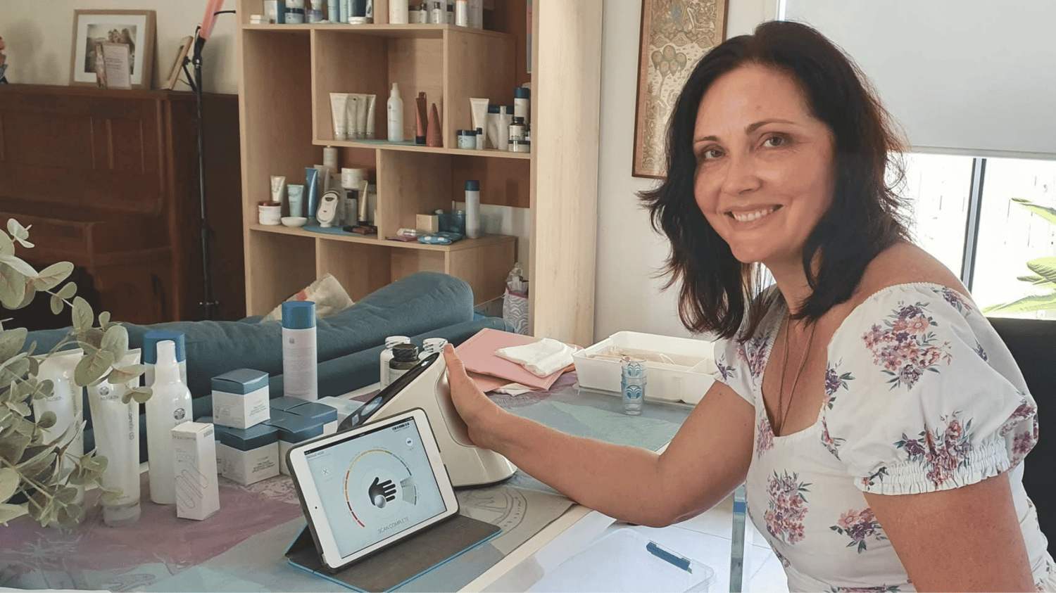 Inner Bliss Wellness Space founder and natural healing massage therapist Natalie at her desk with wellness products Maudsland Gold Coast
