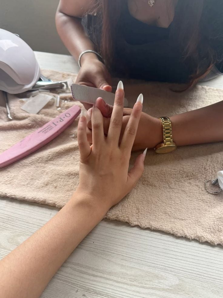 Nail technician engaging with a loyal client to encourage repeat visits in a modern salon.