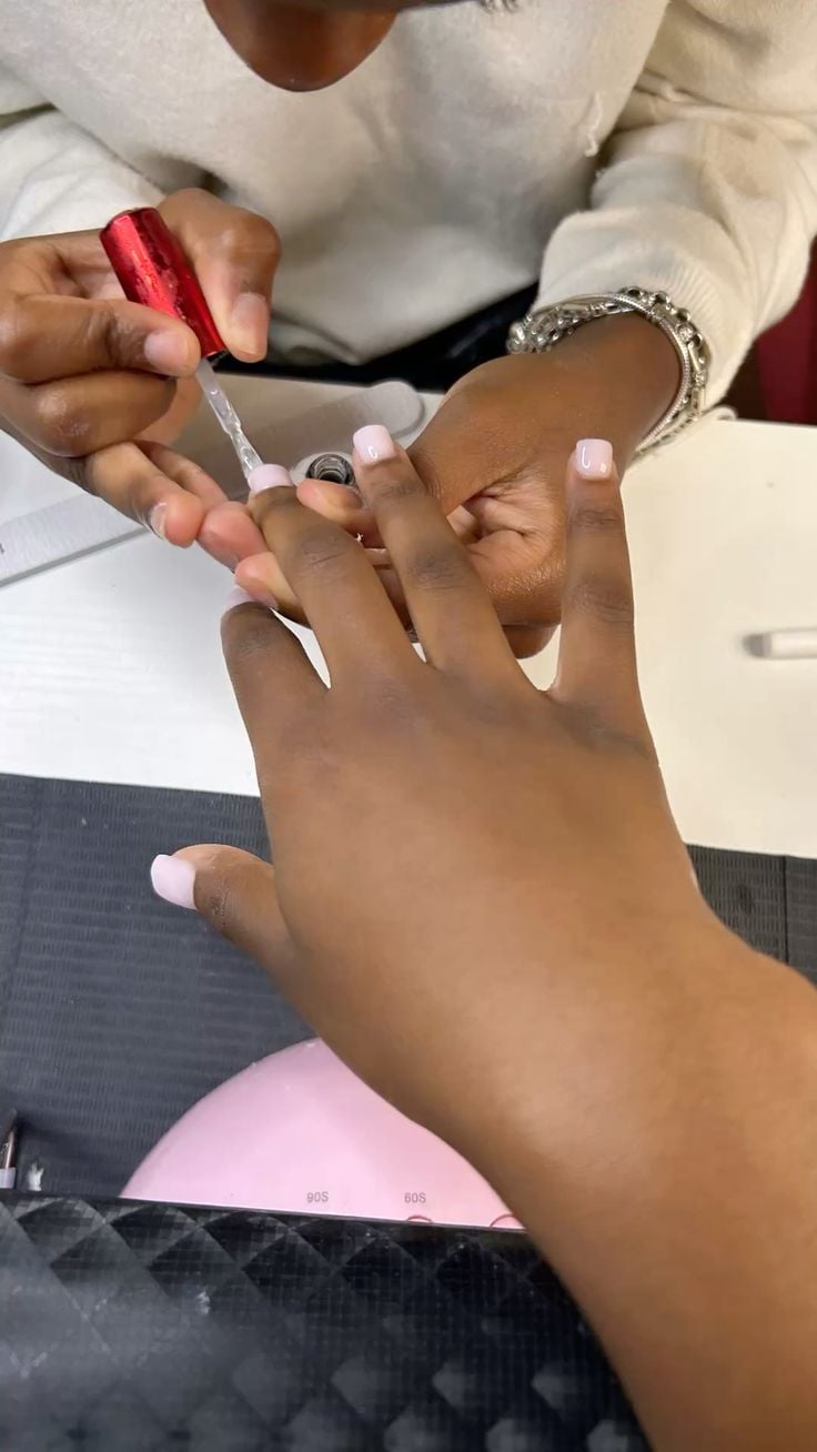 Nail technician managing salon scheduling and workflow efficiently.
