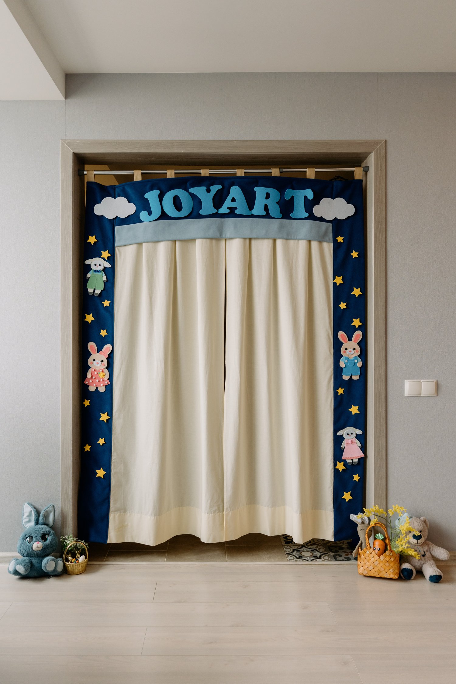 Handmade JoyArt doorway puppet theatre sewn from PDF sewing pattern — navy felt with stars and cream curtains by MUNA Patterns