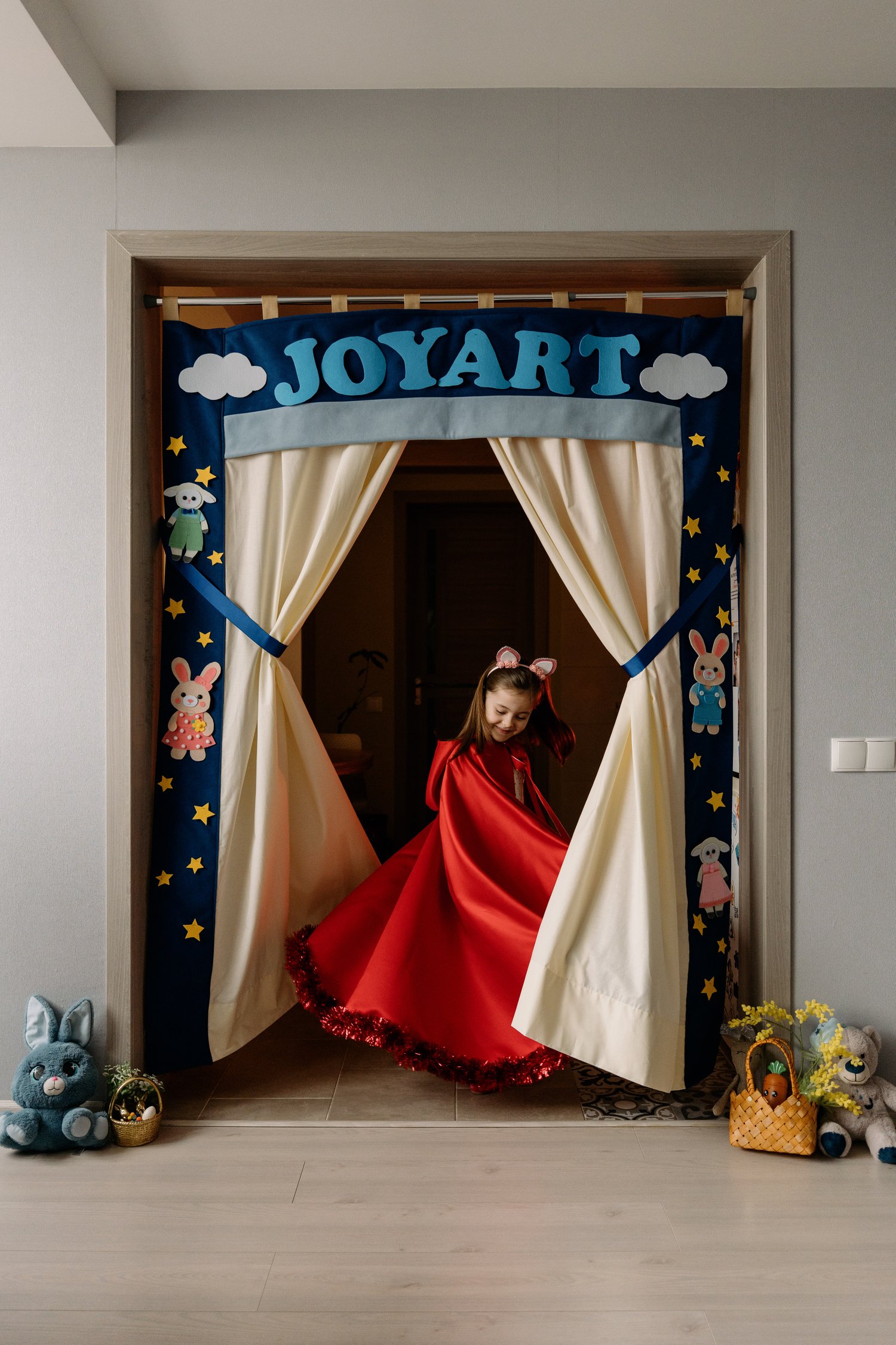 Child performing in handmade JoyArt doorway puppet theatre with Easter felt puppets — kids creative play sewing pattern by MUNA Patterns