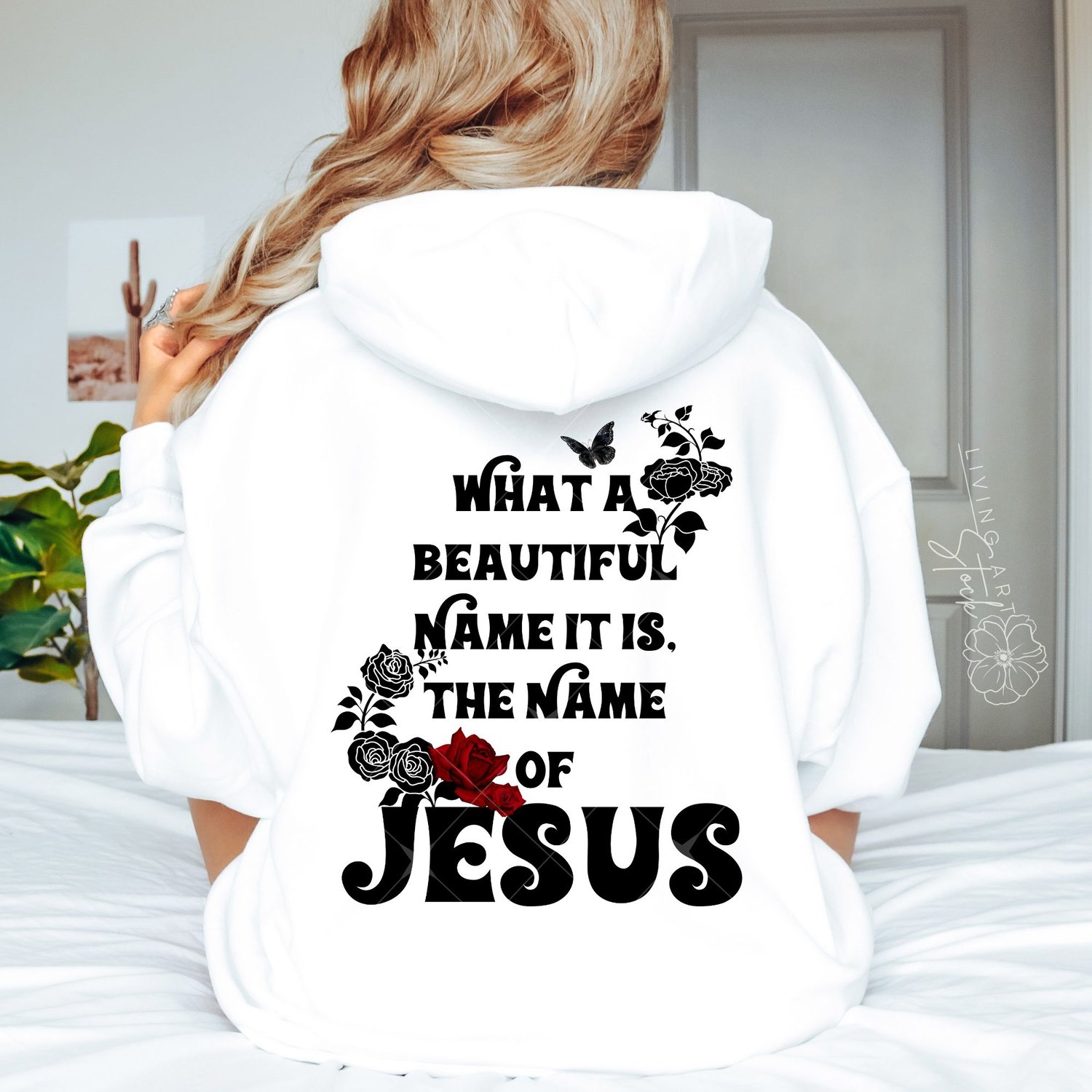 Black stylized text quote "What a Beautiful Name It Is, The Name of Jesus" on a white background, featuring red and black rose illustrations and a black butterfly.