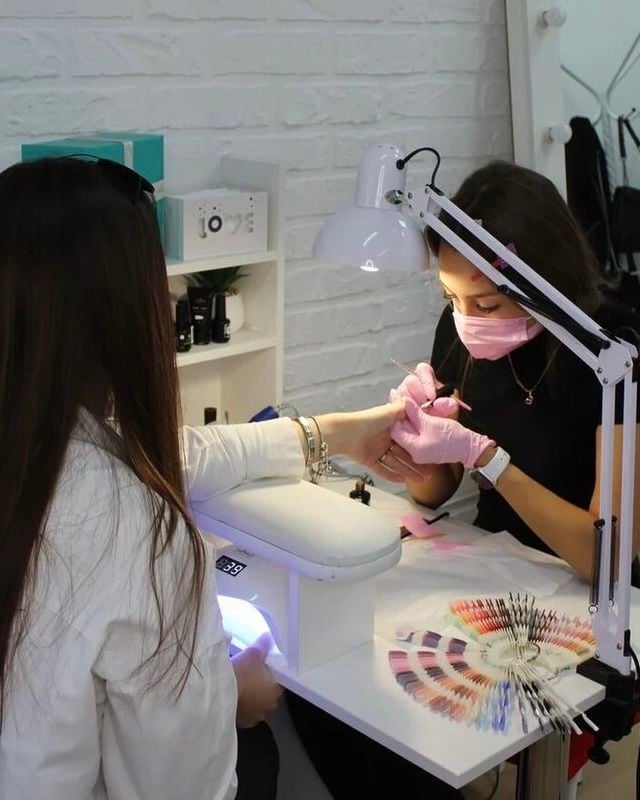 Nail technician managing salon pricing strategy to balance profitability and client satisfaction.
