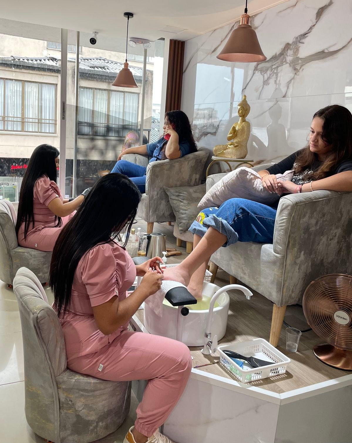 Nail technician presenting add-on options to a client without being pushy in a modern nail salon.