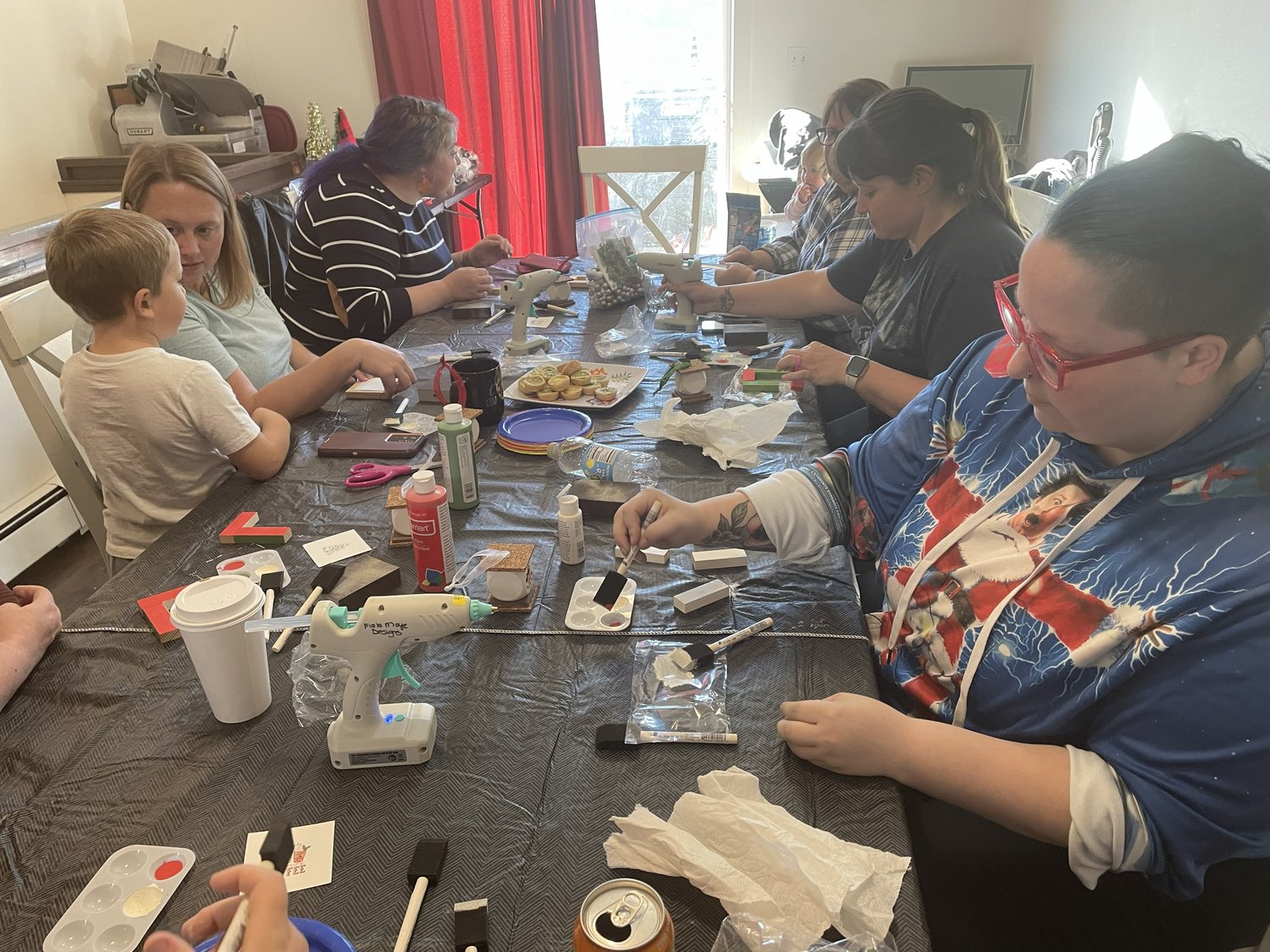 Group of participants gathered around a table working on craft projects during a workshop.