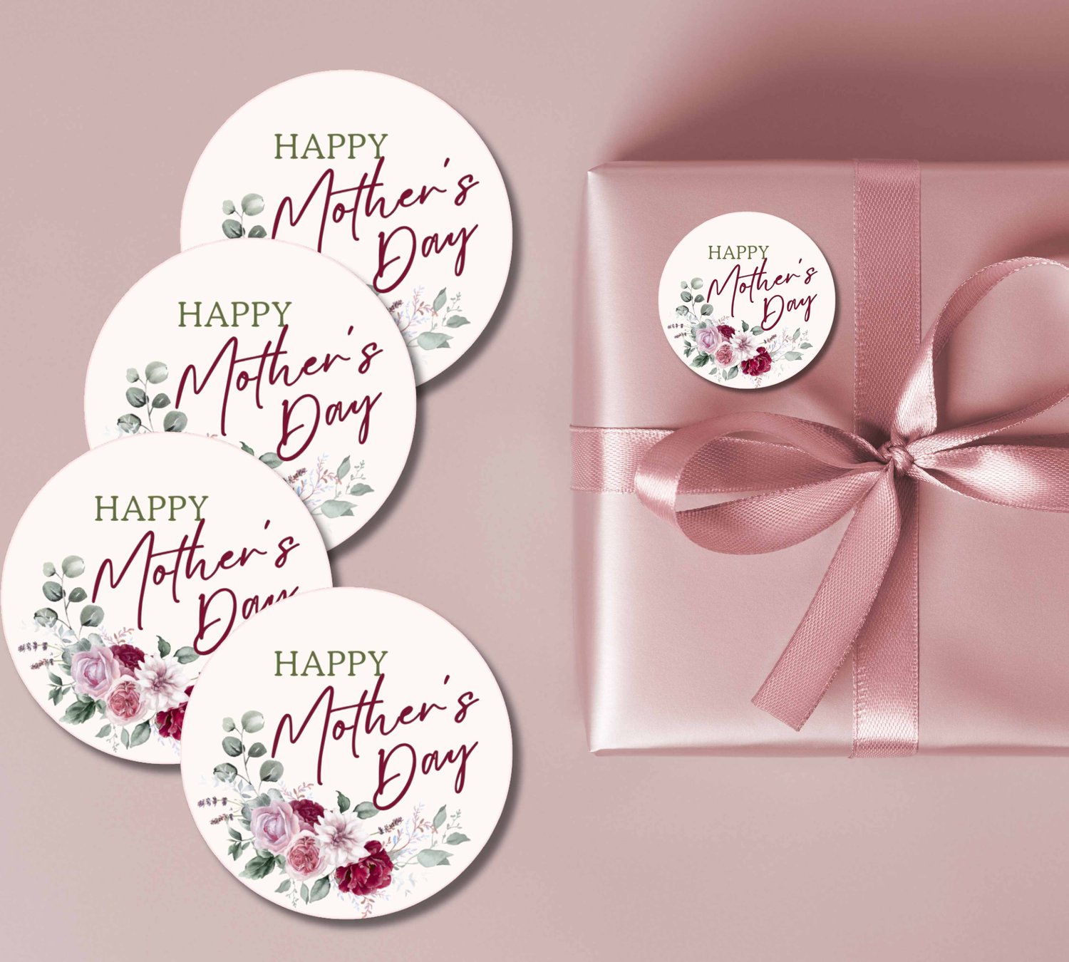 Pink gift box with satin bow, accompanied by five round floral “HAPPY Mother’s Day” stickers in pink and burgundy.