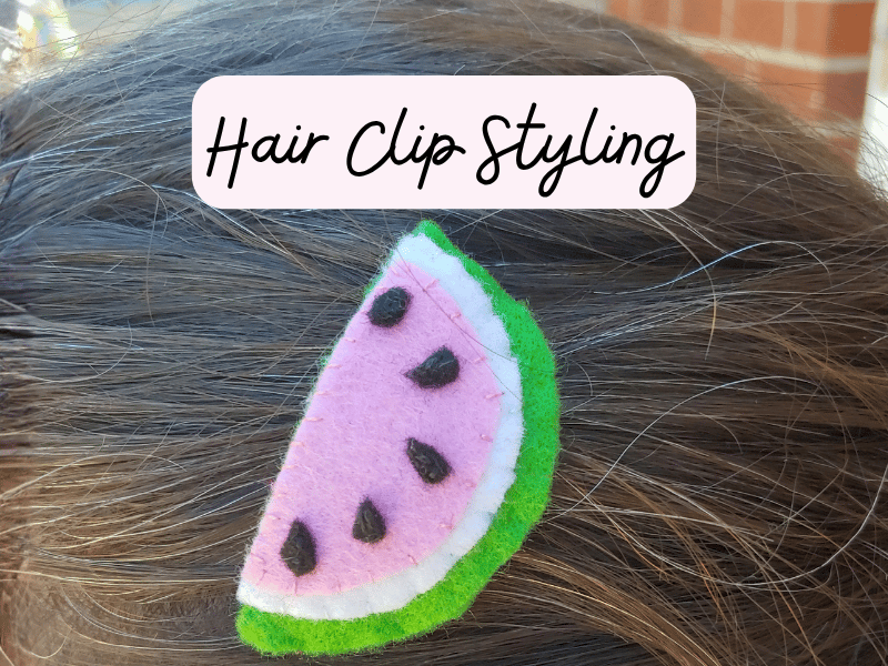 Felt watermelon slice hair clip that is clipped onto hair